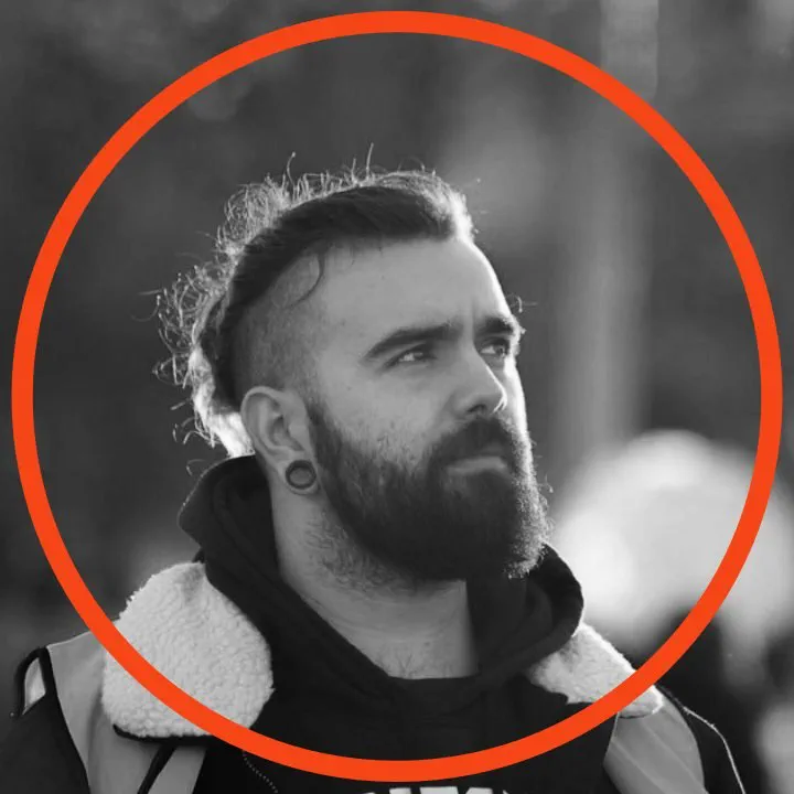 Retrato de Raúl Buch en blanco y negro dentro de un círculo naranja